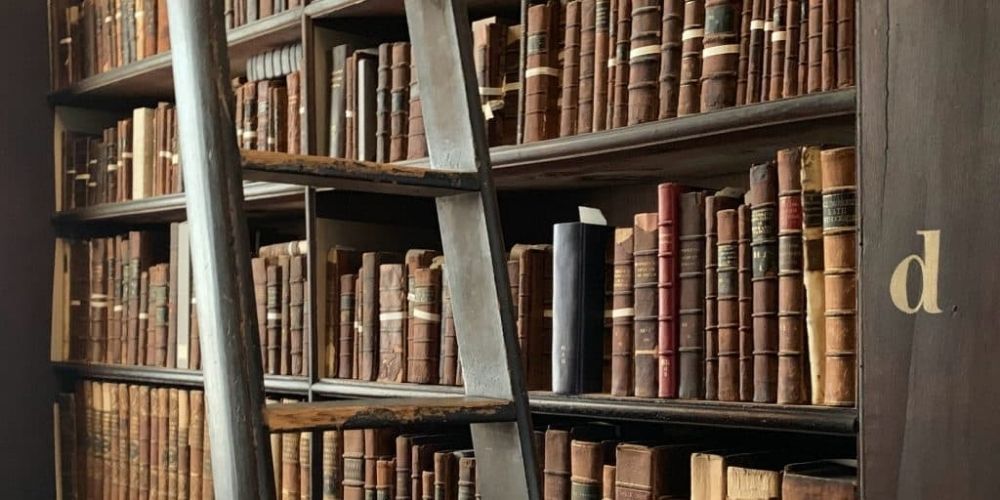 A shelf with lots of old books.
