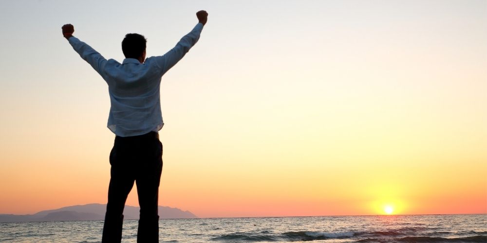 A free man standing outside as the sun rises.