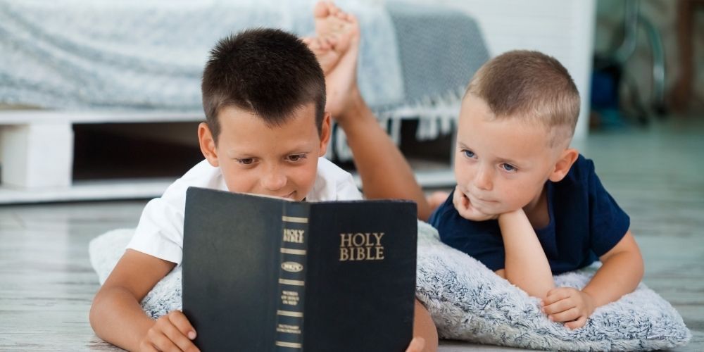 Two boys reading the Bible.