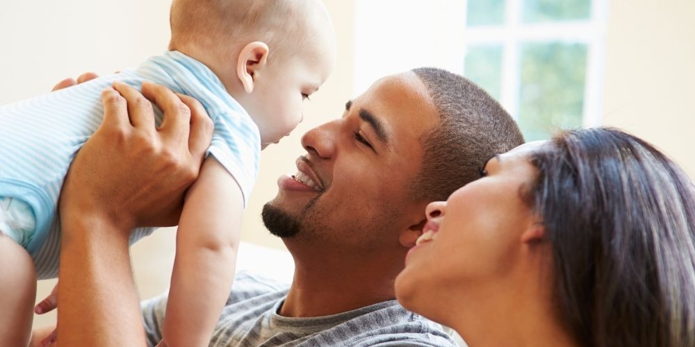 A man holding an infant next to his wife.
