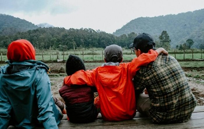 A dad sitting on a porch with his family.