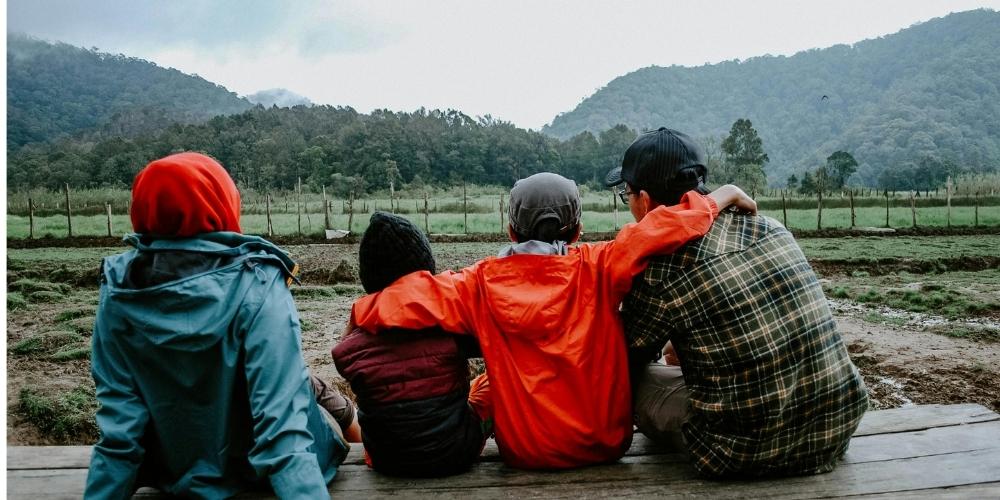 A dad sitting on a porch with his family.