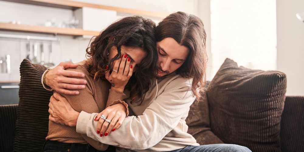 A husband comforting his sad wife.