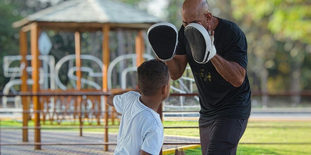 Dad teaching his son how to box.