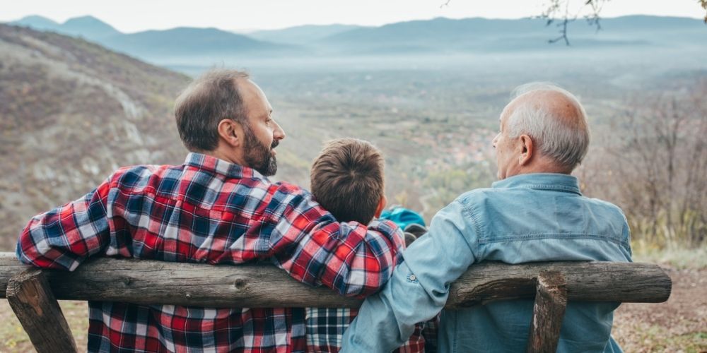 Generational shot of a dad with his son, who is with his son.